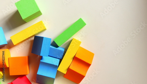 Childrens playing colored geometric shapes close-up top view on a light table selective focus.