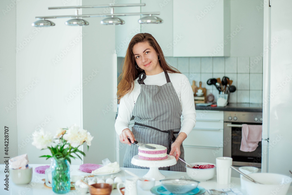 Young beautiful woman bakes a cake. Sweets. Confectionery.