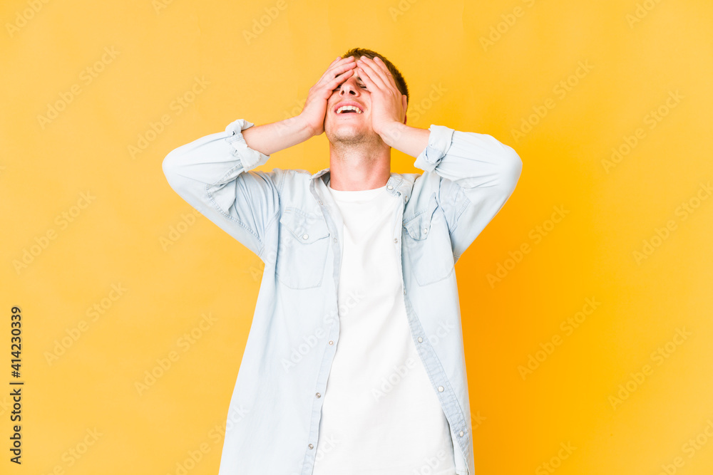 Young caucasian handsome man laughs joyfully keeping hands on head. Happiness concept. Young caucasian handsome man laughs joyfully keeping hands on head. Happiness concept.