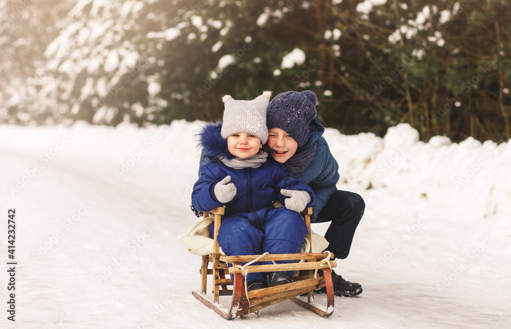 Brother and sister play in the winter on the street. Children's games in nature