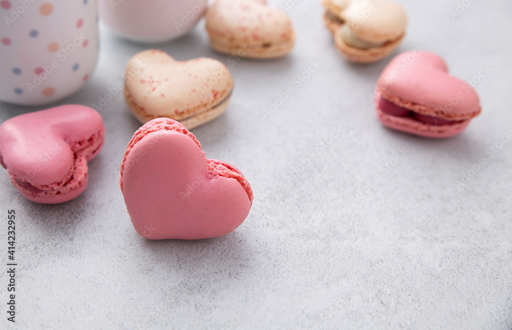 Macarons or French macaroons in heart shapes is a sweet meringue-based confection on gray background with copy space. Macarons or French macaroons in heart shapes is a sweet meringue-based confection on gray background with copy space.