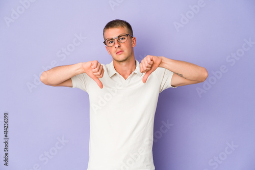 Young caucasian handsome man showing a dislike gesture, thumbs down. Disagreement concept.