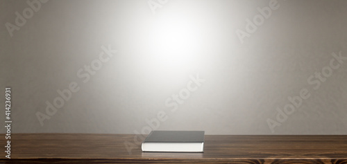 The black book lies on a wooden table. In room