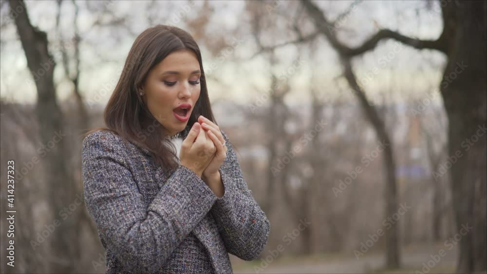a beautiful young girl in a coat freezes on the street, an attractive woman is resting outdoors. a beautiful young girl in a coat freezes on the street, an attractive woman is resting outdoors.