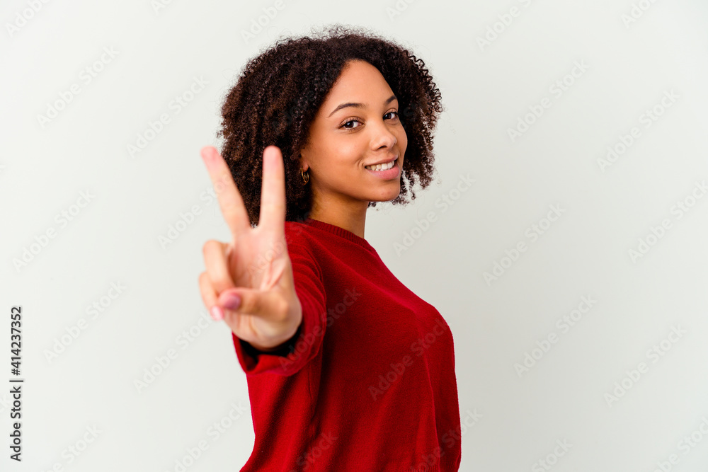Young african american mixed race woman isolated showing victory sign and smiling broadly. Young african american mixed race woman isolated showing victory sign and smiling broadly.
