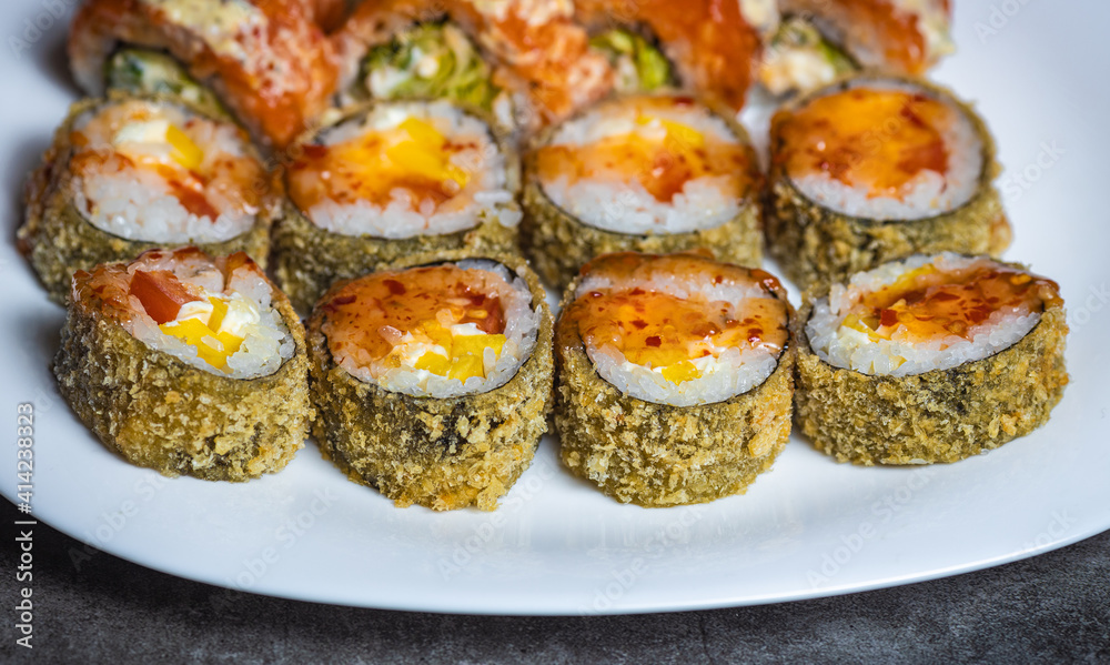 Hot fried sushi roll with salmon. Sushi menu. Japanese food. Hot fried sushi rolls on white plate Hot fried sushi roll with salmon. Sushi menu. Japanese food. Hot fried sushi rolls on white plate