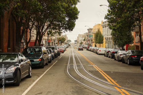 A straight and empty street in San Francisco with cars parked on both sides, California, United States of America aka USA