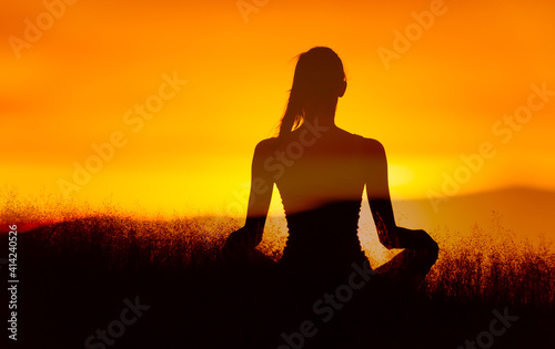 silhouette of a person in yoga position at sunset. Wellness, and relaxed state of mind concept. 