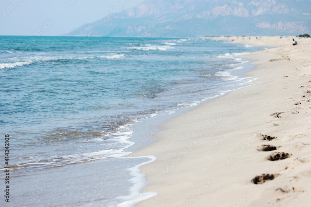 Sandy beach and blue sea waves. Beautiful nature background.