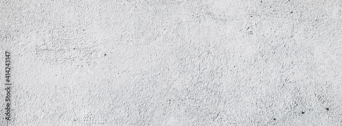 Plastered light gray wall surface background with scratches and cracks. High resolution grungy wall texture. Panoramic banner © Aliaksei