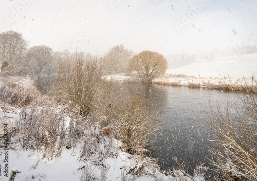 Falling snow over the Teviot River in the Scottish Borders, UK