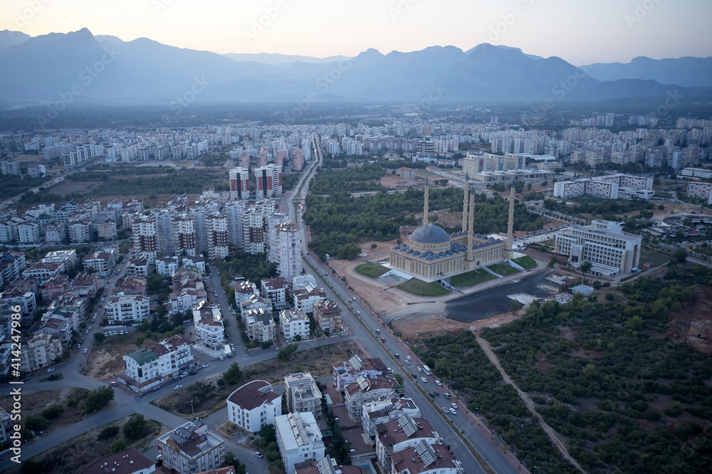 Panoramic view of Antalya town landscape with Mosque Minaret view. Cityscape of Antalya with blue Mosque. Mountains silhouettes in the background.