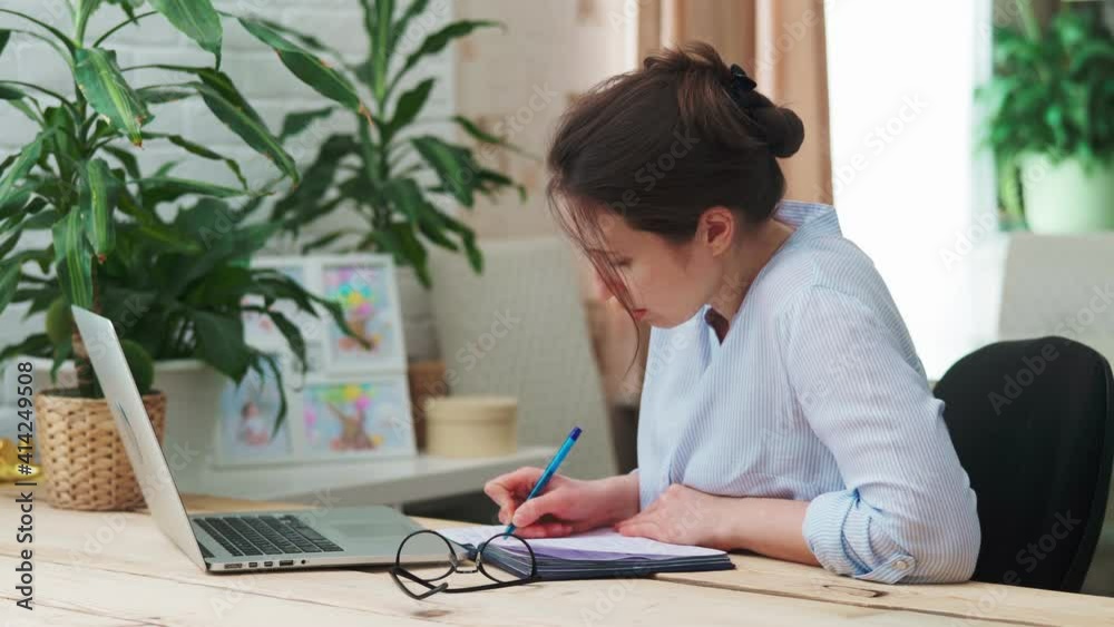 young woman, a businesswoman, works with documents at the computer, at home with her child. The girl is bored and wants to play and get her mother's attention. My daughter distracts mother from work. young woman, a businesswoman, works with documents at the computer, at home with her child. The girl is bored and wants to play and get her mother's attention. My daughter distracts mother from work.