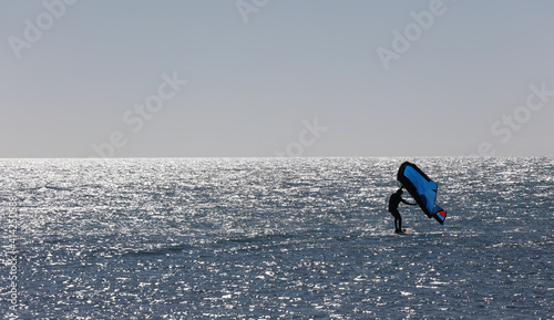 Man practicing with wing-surfer at sunset in the sea © Fernando