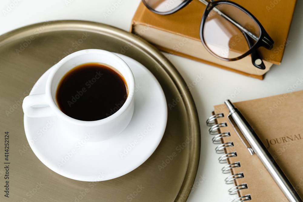 Cup of coffee, glasses, pen and notepad on the table Cup of coffee, glasses, pen and notepad on the table
