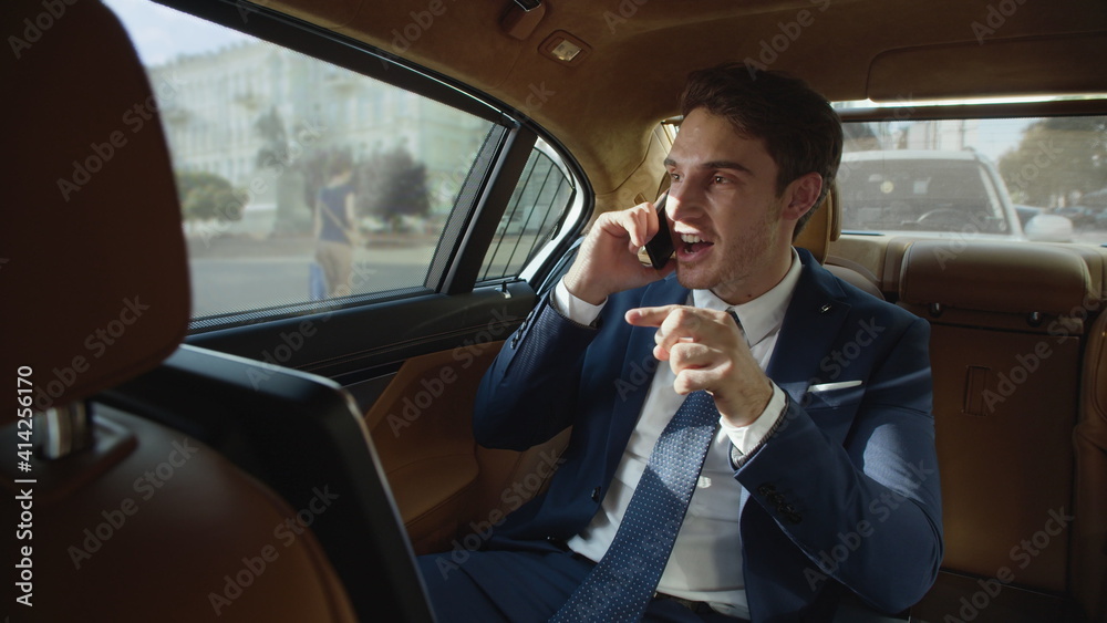 Strict business man swearing on mobile phone in back seat of luxury automobile. Strict business man swearing on mobile phone in back seat of luxury automobile.