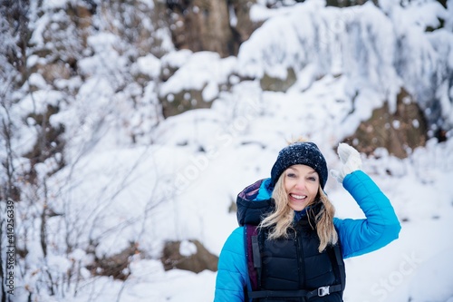 Happy, smiling female tourist in beautiful winter scenery in the mountains. Active recreation.