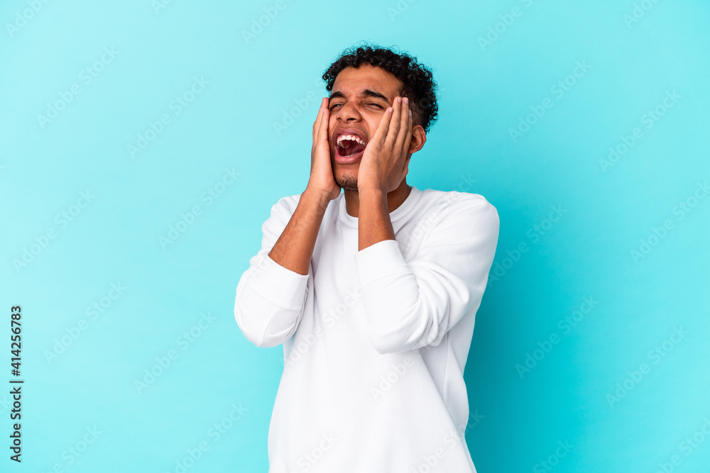 Young african american curly man isolated on blue whining and crying disconsolately.