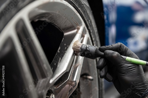 Obraz na płótnie Car detailing studio worker cleaning car wheel with brush w salonie