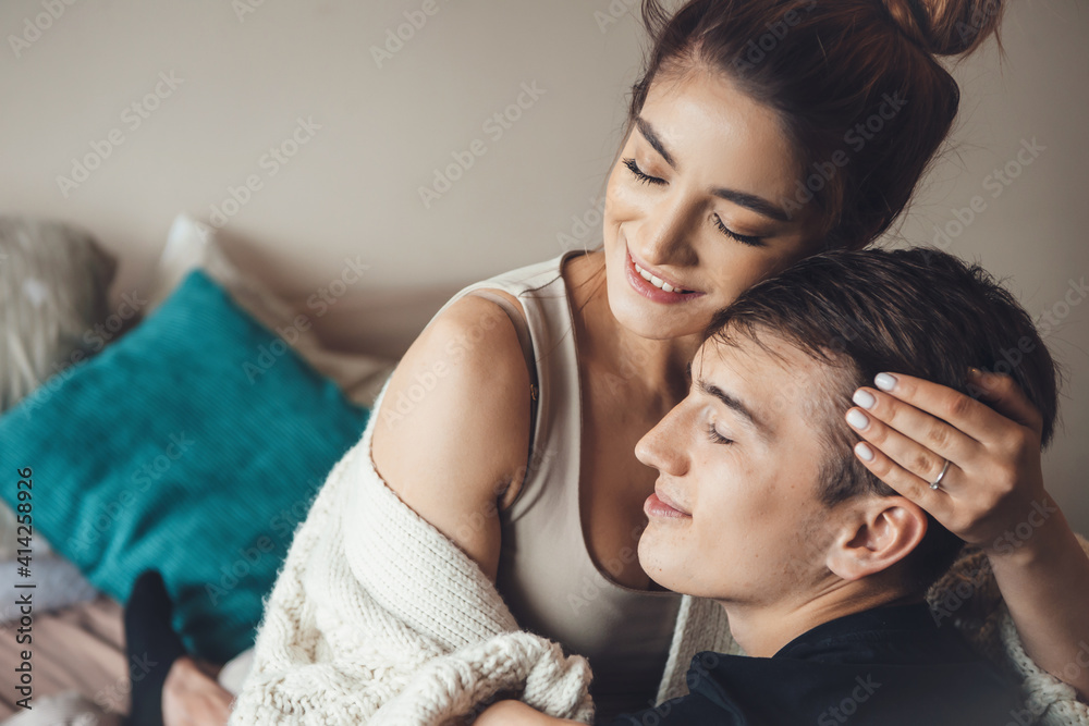 Obraz premium Close up photo of a woman embracing her lover and smile in bed in a sweet morning together