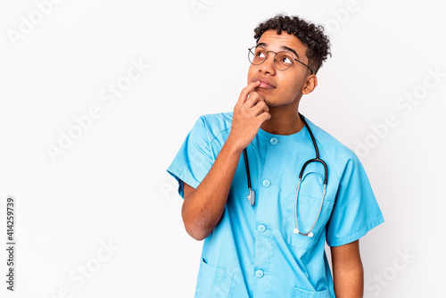 Young african american curly nurse man isolated relaxed thinking about something looking at a copy space.