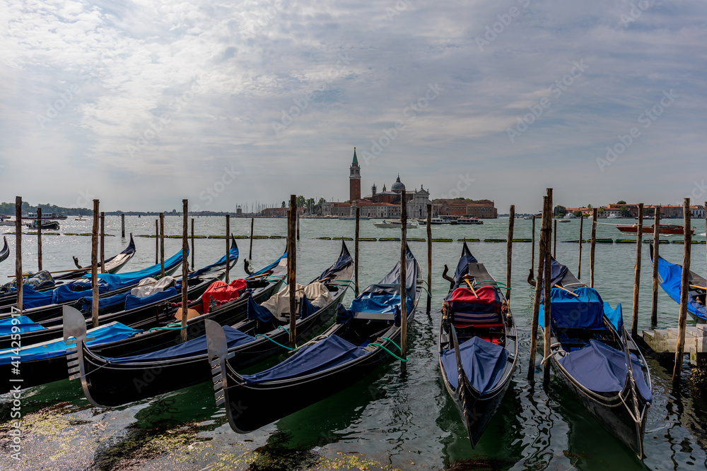 Gondolas parked on a pier in Venice Italy.