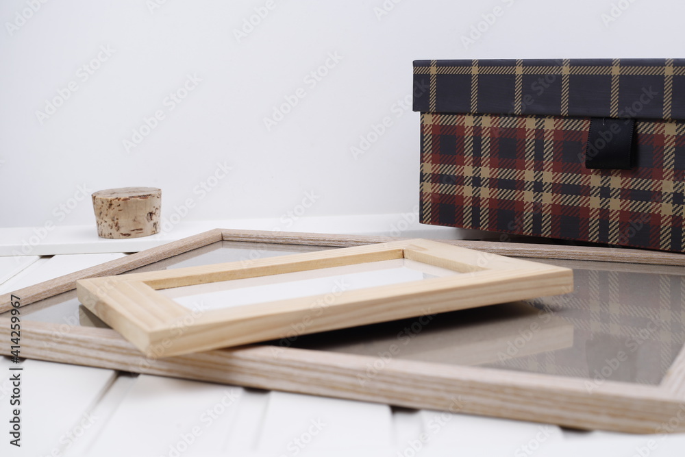 Pudełko tekturowe w kratę i ramki jasne drewniane - obrazy, fototapety, plakaty 