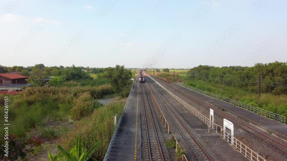 Train Moving On An Open Railway In A Rural Area In Thailand. static wide shot Train Moving On An Open Railway In A Rural Area In Thailand. static wide shot