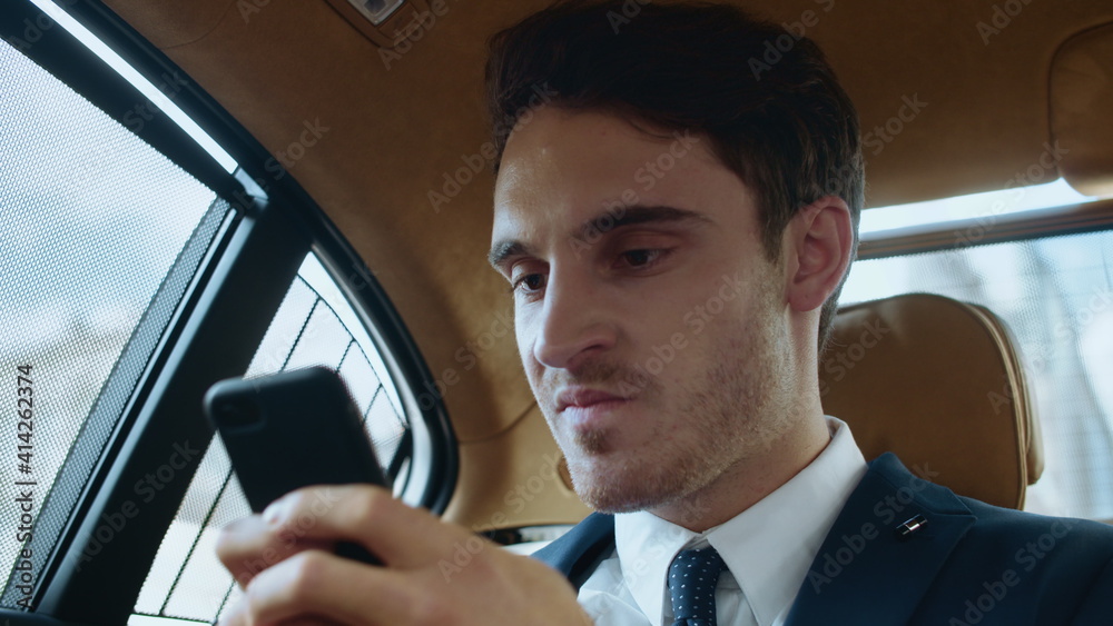 Portrait of annoyed business man working with mobile phone in automobile. Portrait of annoyed business man working with mobile phone in automobile.