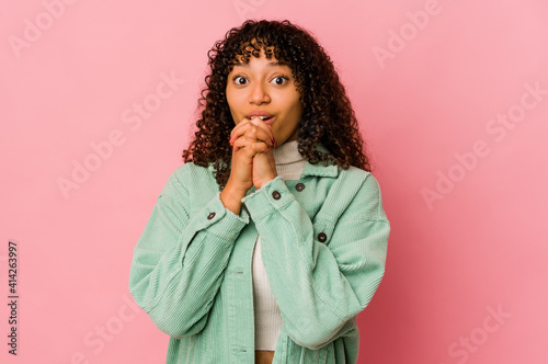 Young african american afro woman isolated praying for luck, amazed and opening mouth looking to front.