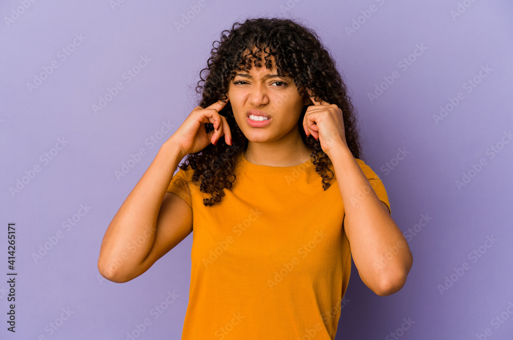 Young african american afro woman isolated covering ears with fingers, stressed and desperate by a loudly ambient. Young african american afro woman isolated covering ears with fingers, stressed and desperate by a loudly ambient.