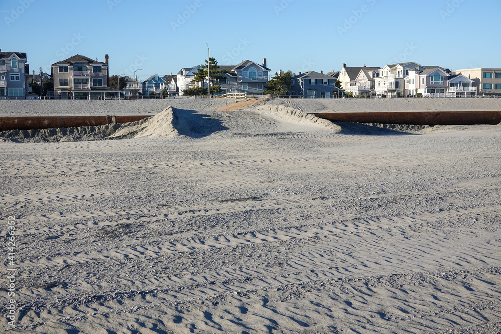 Sand filed om top of a pipeline over a sandy beach to act as a bridge for people and vehicles