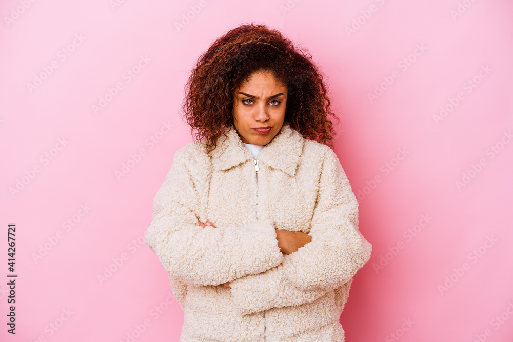 Young african american woman isolated on pink background blows cheeks, has tired expression. Facial expression concept. Young african american woman isolated on pink background blows cheeks, has tired expression. Facial expression concept.