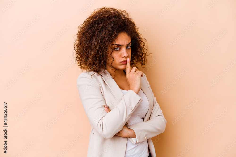 Young african american woman isolated on beige background unhappy looking in camera with sarcastic expression. Young african american woman isolated on beige background unhappy looking in camera with sarcastic expression.