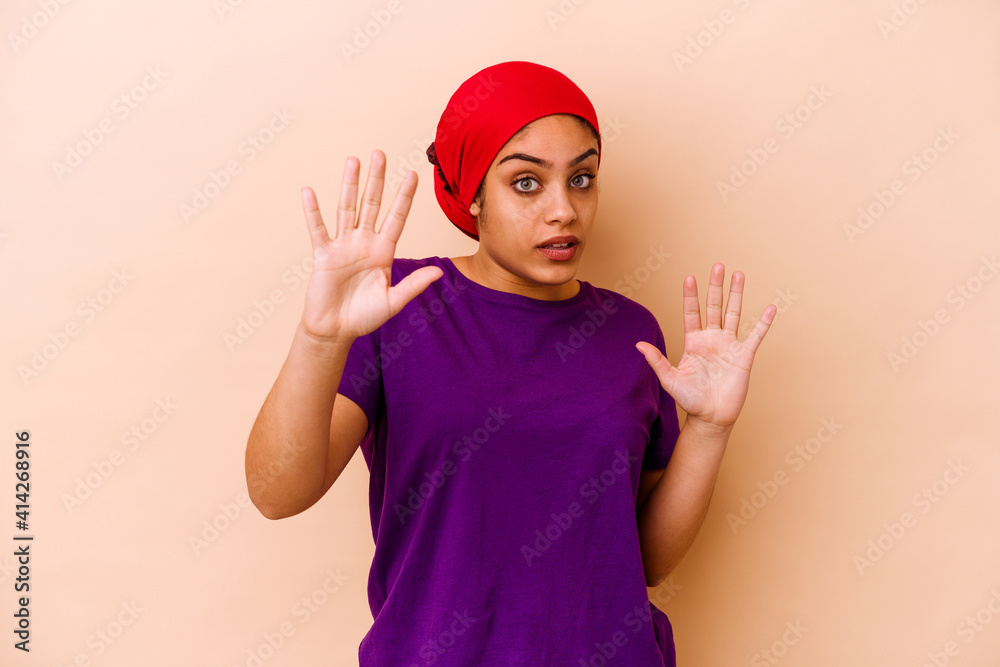 Young african american woman isolated on beige background being shocked due to an imminent danger