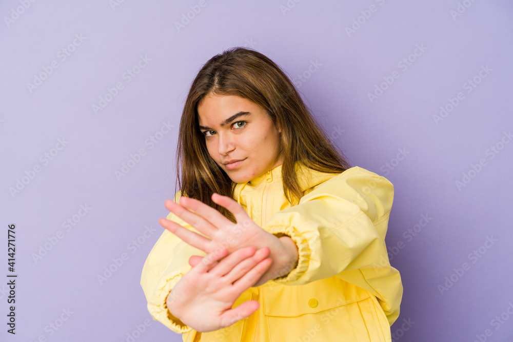 Young skinny caucasian girl teenager on purple background standing with outstretched hand showing stop sign, preventing you. Young skinny caucasian girl teenager on purple background standing with outstretched hand showing stop sign, preventing you.