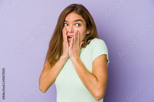 Young skinny caucasian girl teenager on purple background scared and afraid.