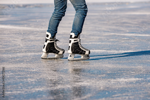 Photography Detail of the black and white mens ice skates in action on ice