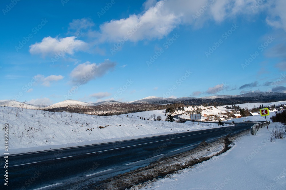 Winter in the mountains. Panorama, blue sky, clouds. 