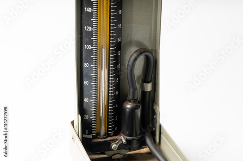 An old mercury sphygmomanometer on a solid color background