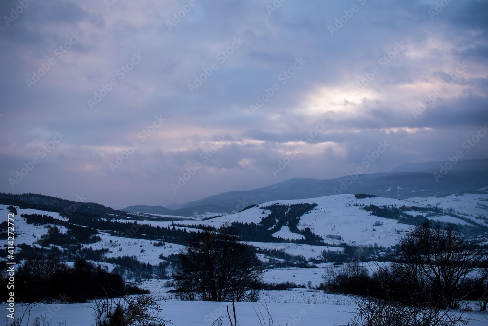 Winter in the mountains. Panorama, evening sky, clouds. 