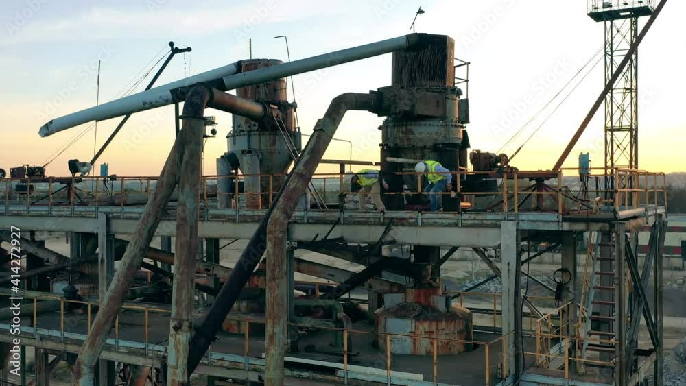 Two engineers are walking through a massive industrial construction Two engineers are walking through a massive industrial construction