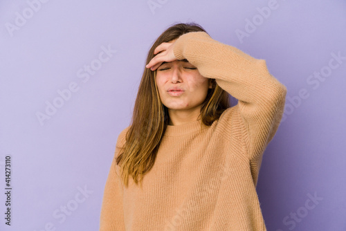 Young skinny caucasian girl teenager on purple background touching temples and having headache.