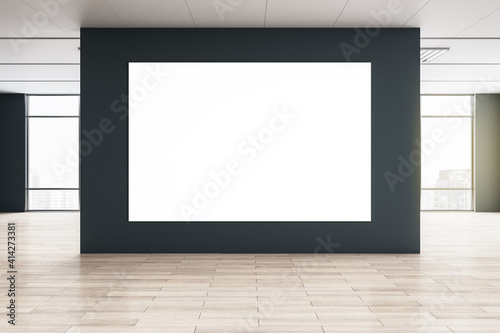 Big blank white poster on black wall in the center of empty eco style hall with big windows and wooden floor. Mockup