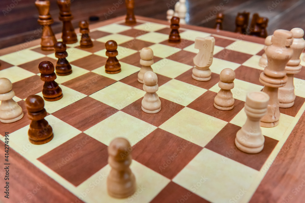 White and black chess pieces stand on board during a chess game White and black chess pieces stand on board during a chess game