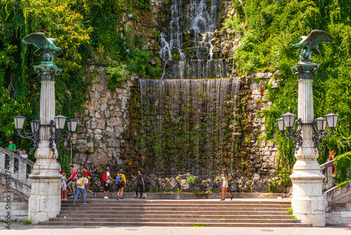BUDAPEST, HUNGARY - JULY, 2019:   Gellért Hill Waterfall, man-made waterfall on Gellert Hill as a pair of Turul lampposts stand guard. photo