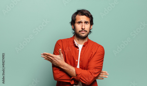 Fotografie young handsome indian man feeling confused and clueless, wondering about a doubt