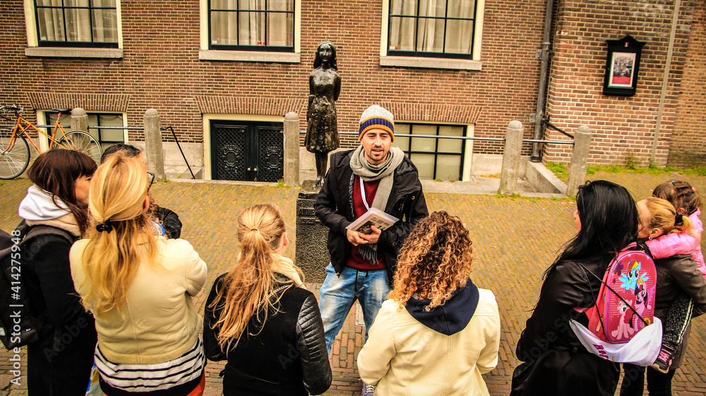 © manuelakanolo - TOUR GUIDE WITH A GROUP OF PEOPLE