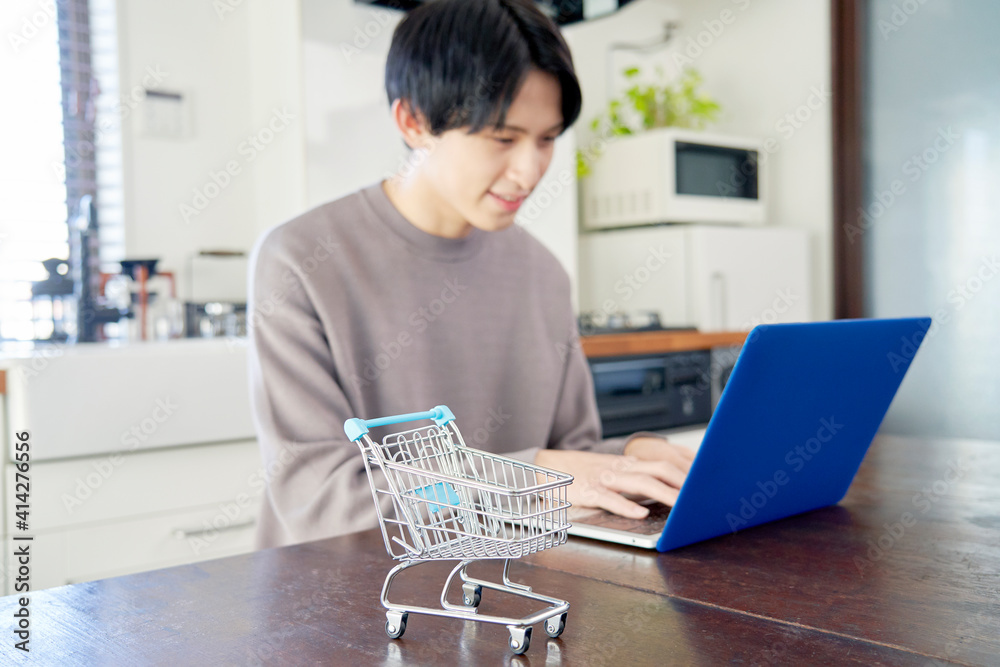 自宅でネットショッピングをする男性 自宅でネットショッピングをする男性
