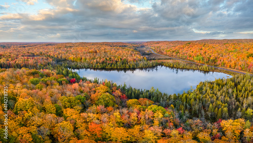 Fototapeta Naklejka Na Ścianę i Meble -  Autumn aerial view of Donken lake on the drive through the tunnel of Trees in Michigan Upper Peninsula UP - Highway 41  M26 Aerial view